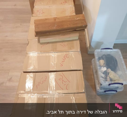 קופסאות קרטון ארוזות עם סרט דבק על רצפה